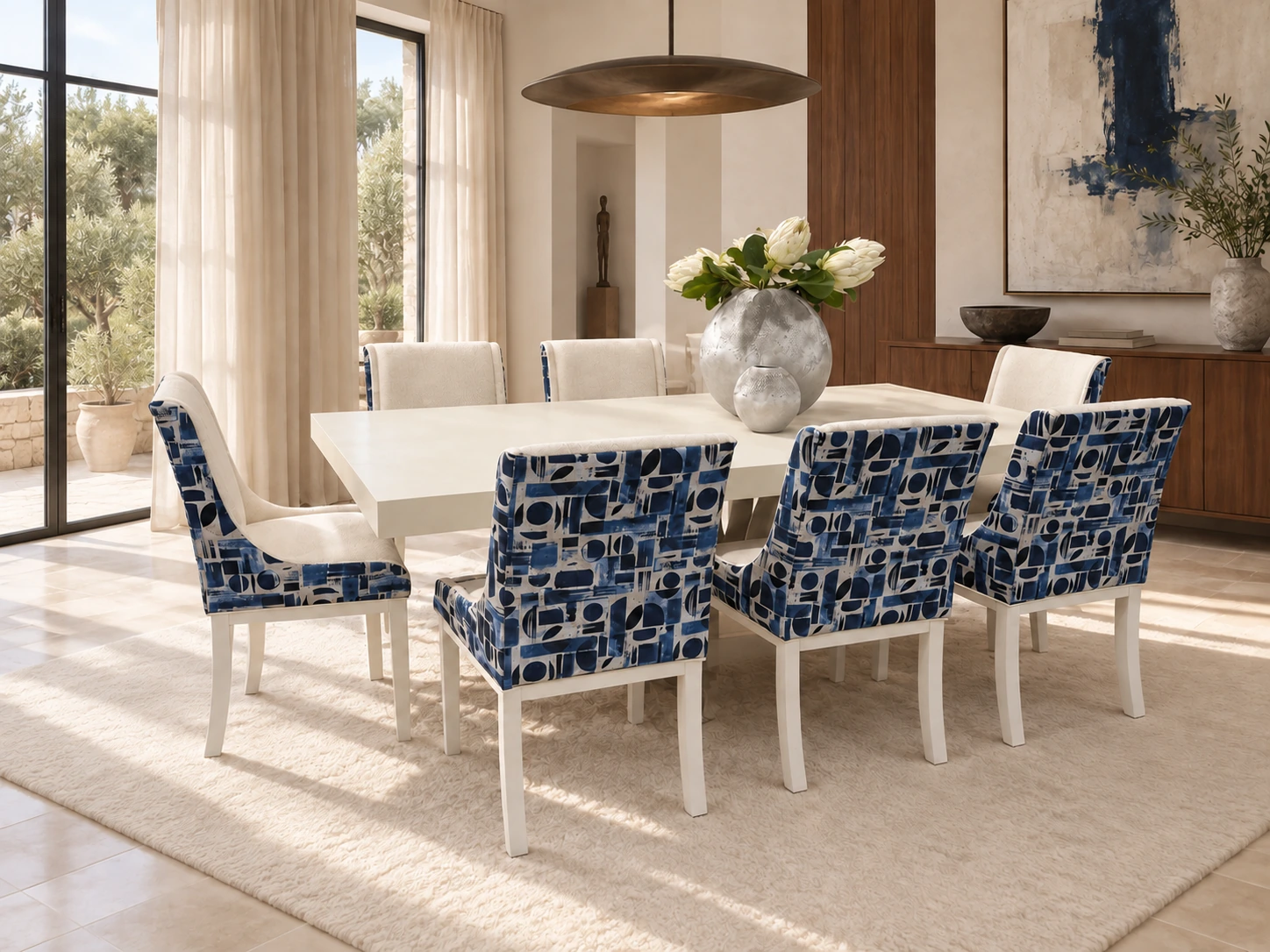 Los Blancos blue and cream geometric dining chairs around an ivory table in a light-filled room with walnut panelling and a bronze pendant