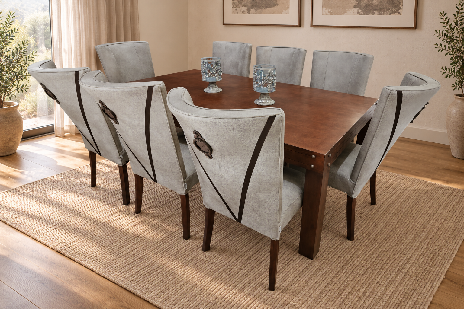 Zambezi grey air-leather dining chairs with dark trim and ring handles around a wooden table in a softly lit room